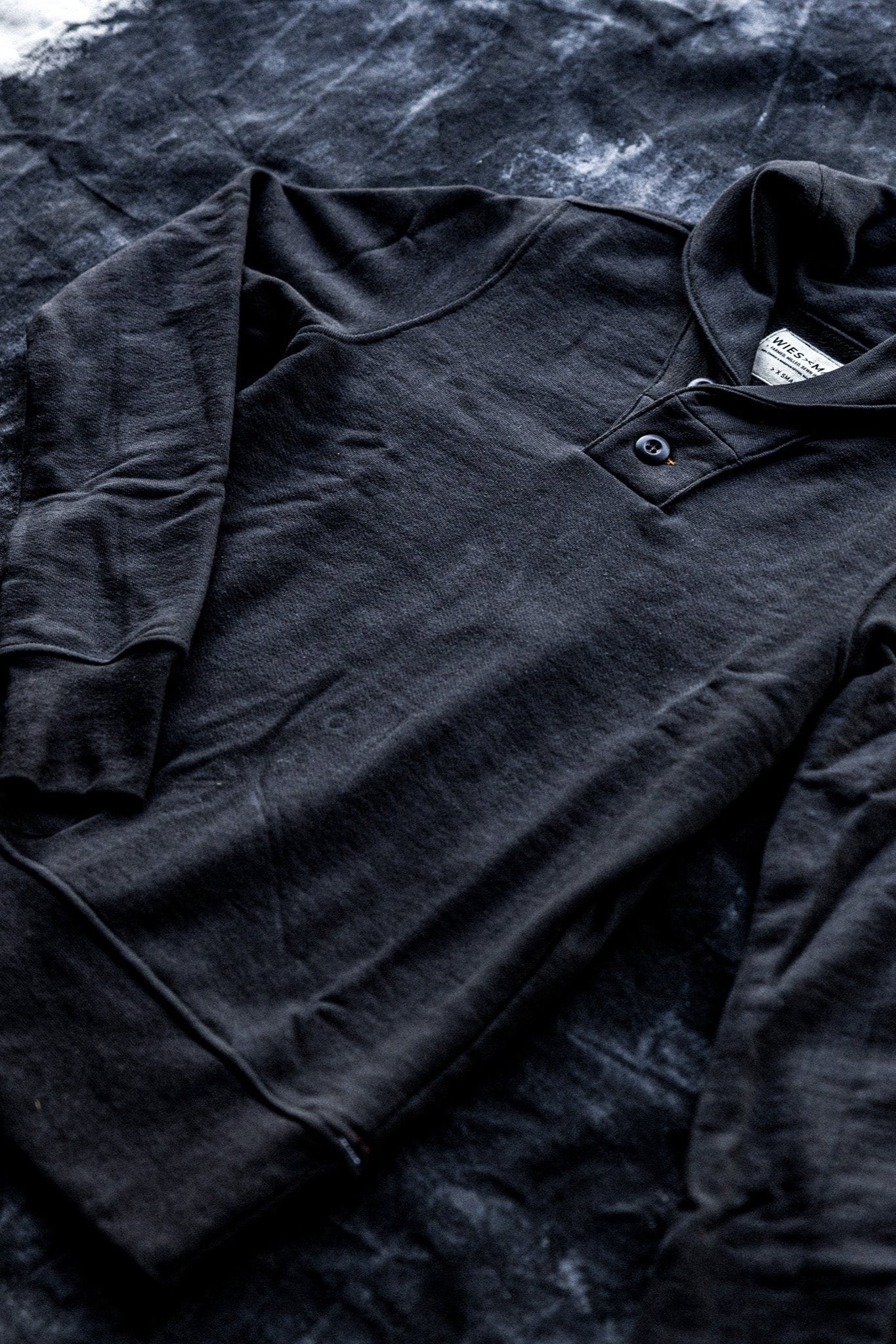 Shawl cardigan men's design in black, featuring a buttoned collar and laid flat for a detailed view.