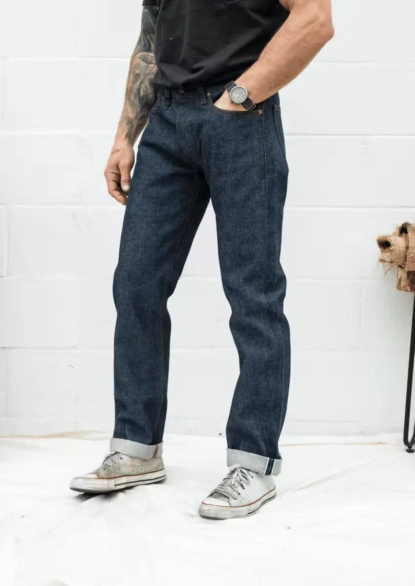 Jack Fit jeans in Raw Selvedge Denim color, worn by a man, featuring a straight-leg fit with rolled cuffs showcasing the selvedge edge