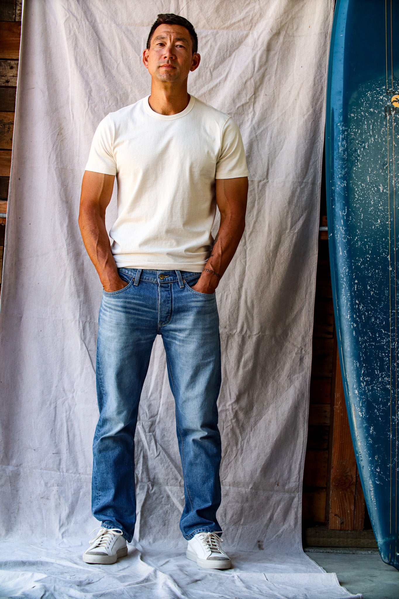 American-made denim jeans in a light wash, styled with a white t-shirt and white sneakers for a classic casual look.