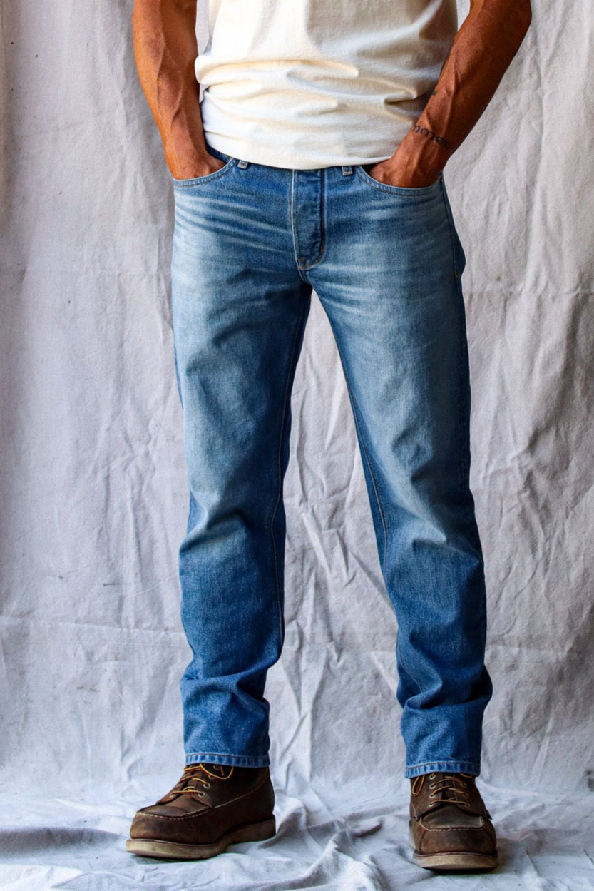 American Blues jeans in a light wash, styled with a white t-shirt and brown work boots for a classic casual look.