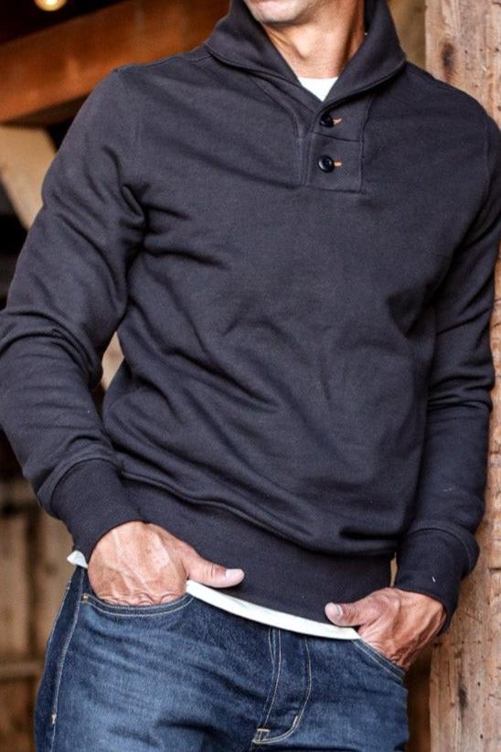Men's shawl cardigan in black with button details, styled casually over a white shirt and jeans.