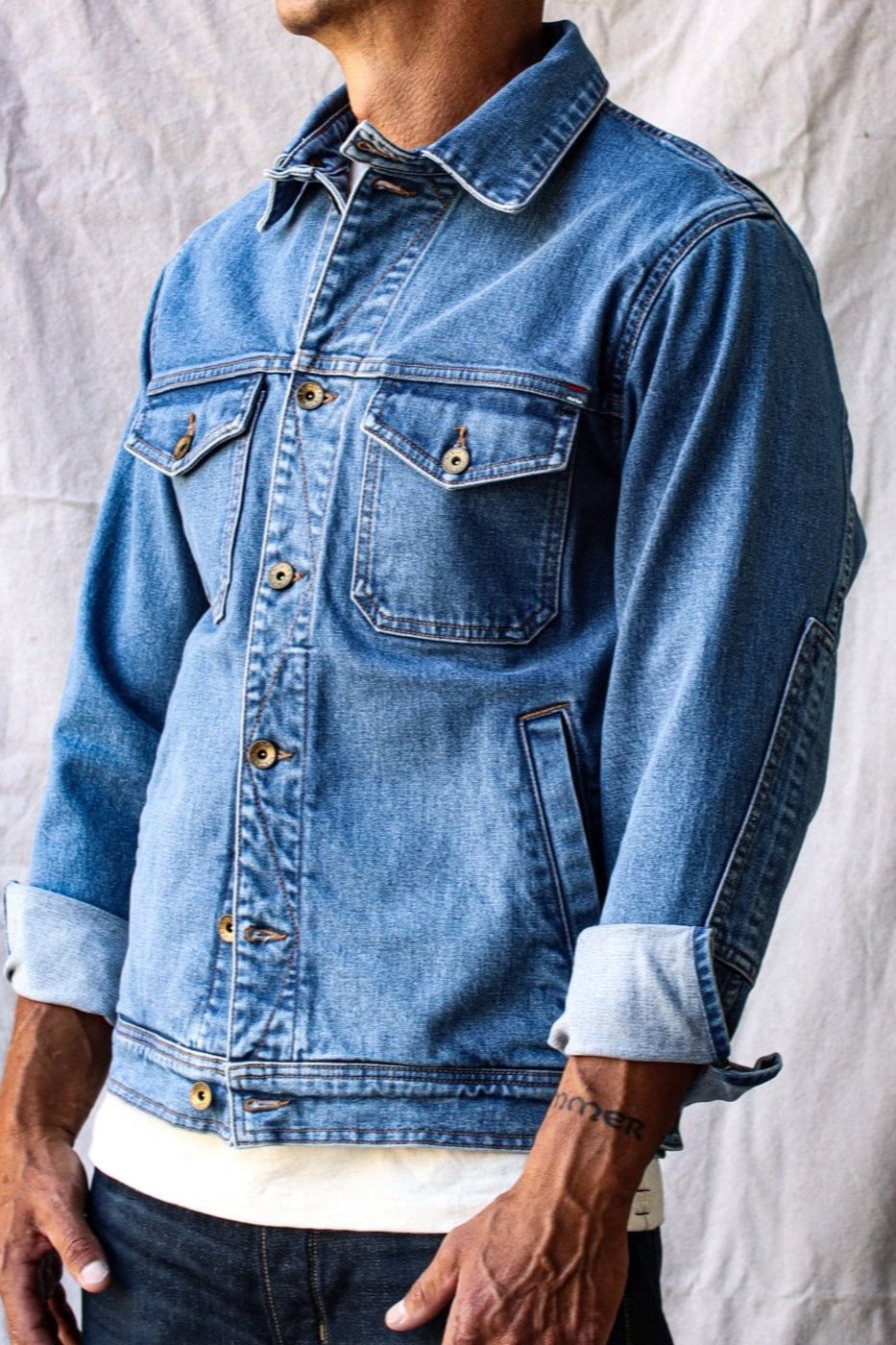 Light-wash denim jacket made in USA, featuring rolled cuffs, chest pockets, and classic rugged styling.
