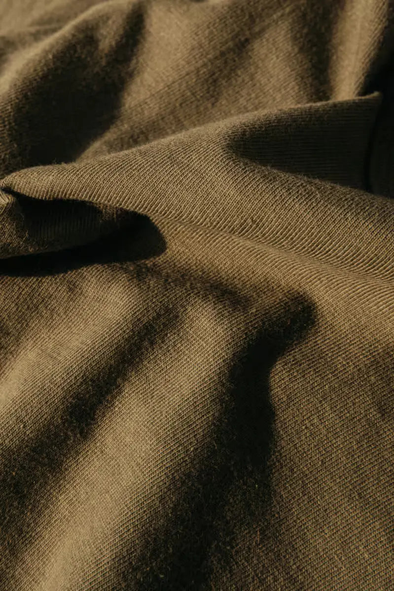 Reyes heavyweight Henley in 8oz 100% cotton in olive color worn by a man, featuring a textured and durable fabric.