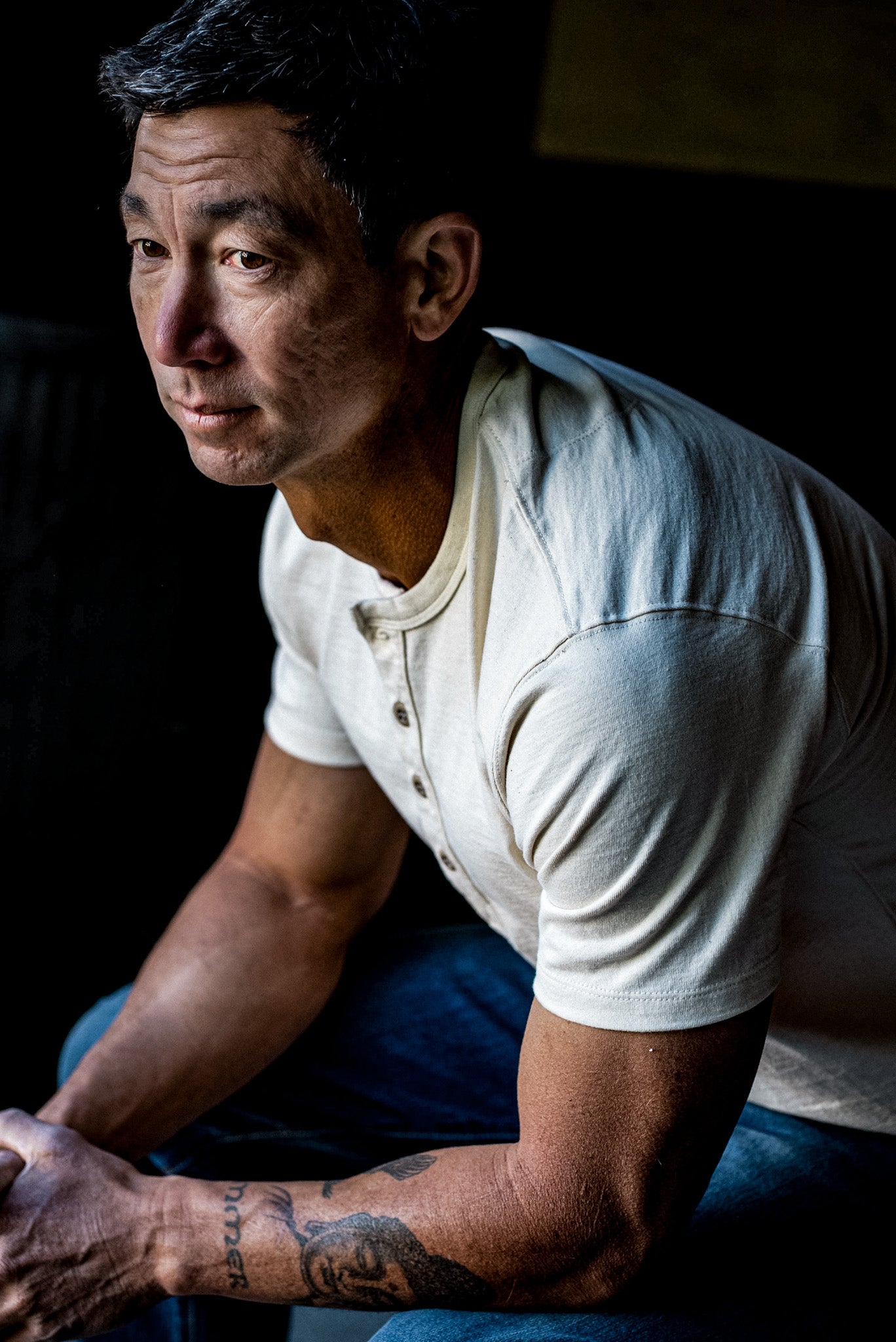 Man in a natural cream short-sleeve Bolinas heavyweight cotton henley with four buttons, paired with blue jeans.