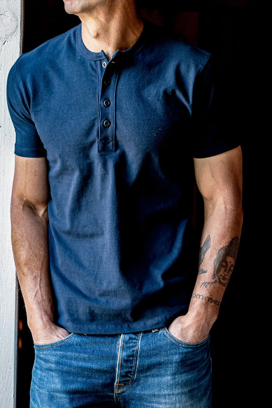 Navy short-sleeve Bolinas Henley with four-button placket, worn untucked with blue jeans.