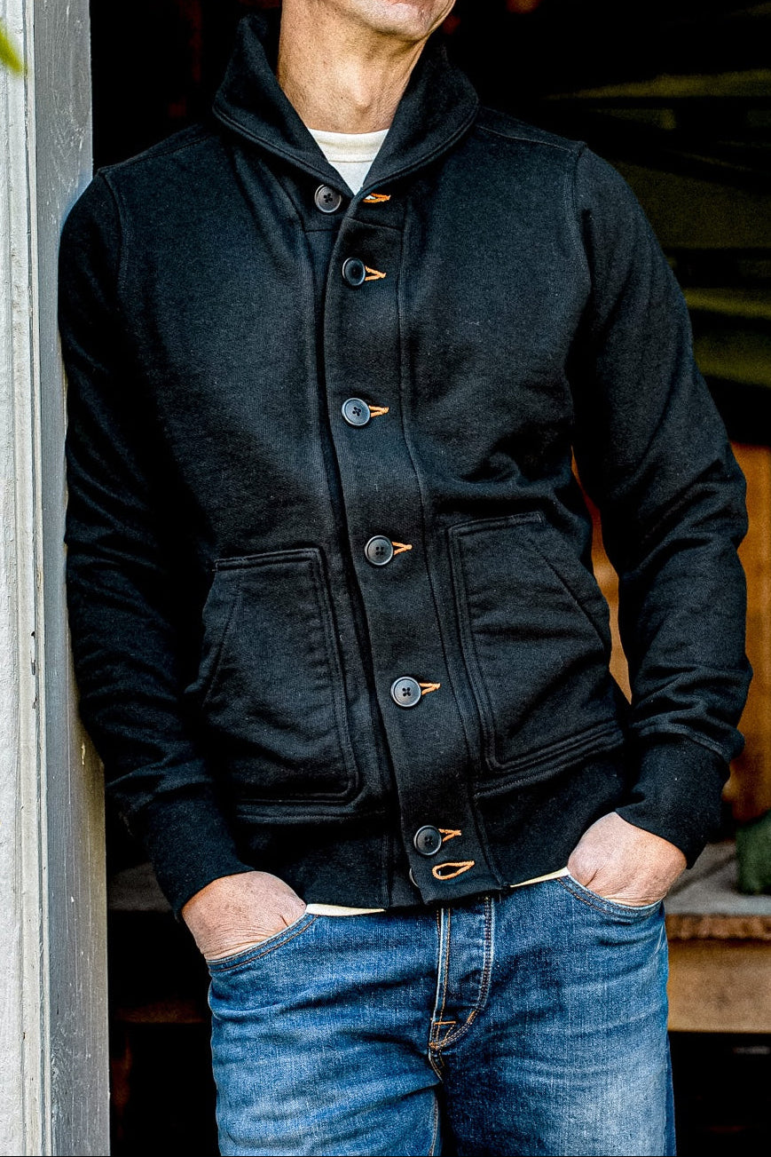 Shawl collar Bodega cardigan in basalt black French terry with contrast tobacco keyholes, worn over jeans.