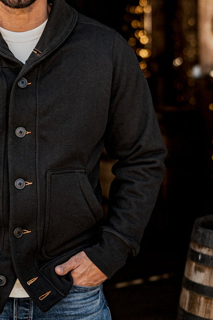 Close-up detail of a men's basalt French terry cardigan showing the shawl collar, buttons, and patch pocket
