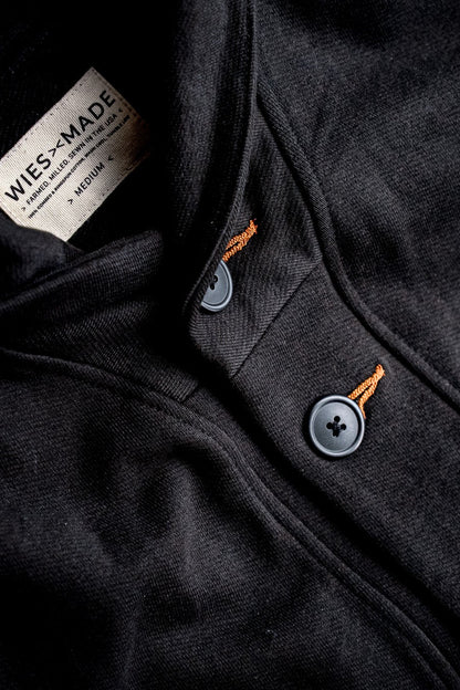 Close-up of basalt black French terry cardigan showing gray buttons, tobacco contrast keyhole stitching, and WiesMade inner.