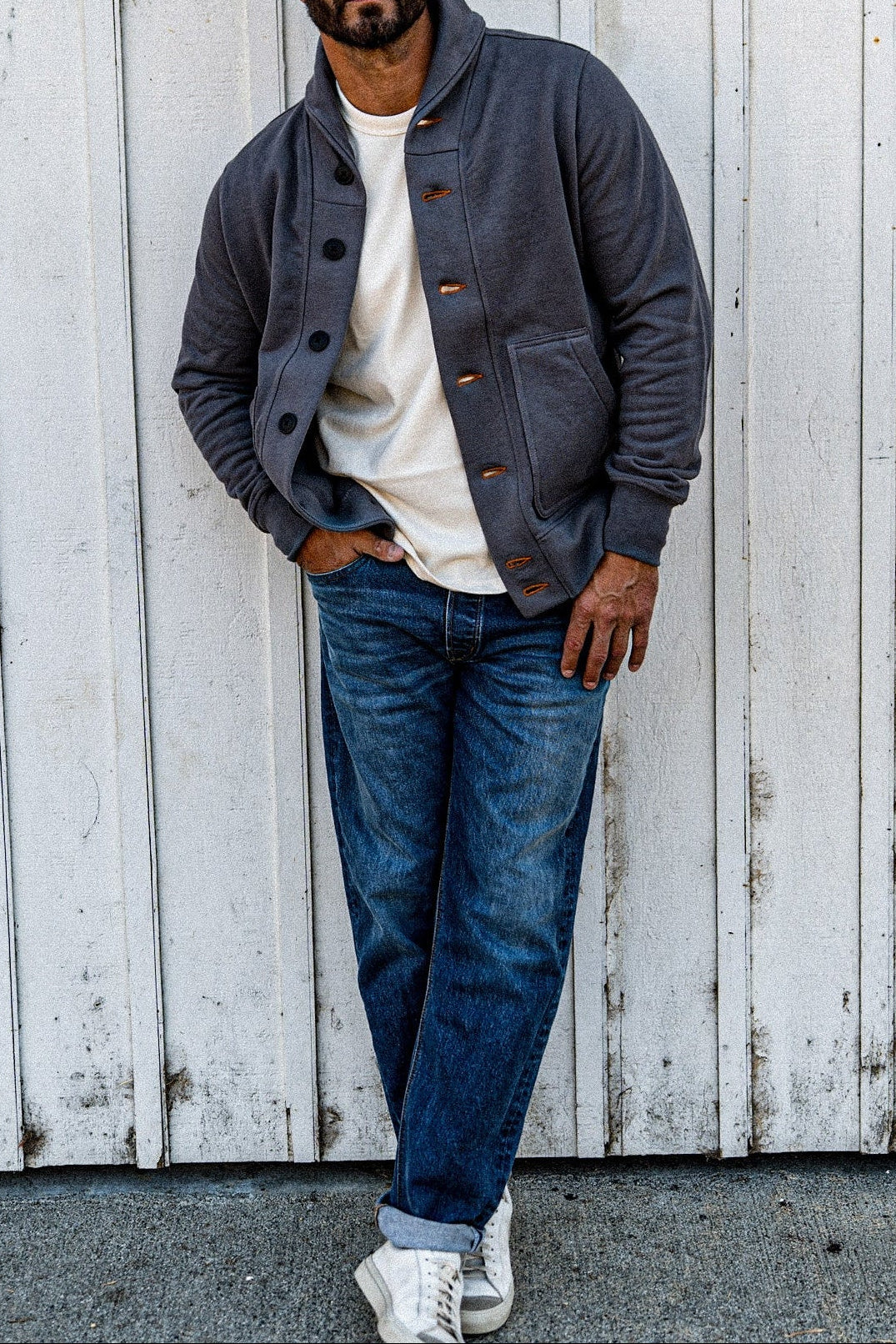 Man wearing a men's pebble French terry cardigan over a cream tee with jeans and white sneakers