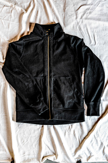 Flat lay of a men's charcoal zip-up moto jacket with snap collar and front patch pockets on a grey backdrop