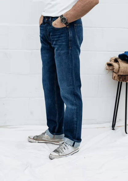 Sam Fit jeans in Washed Selvedge, worn by a man, featuring a standard fit with a clean finish and rolled cuffs