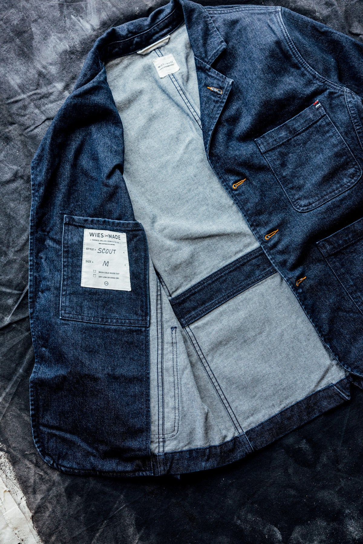Interior flat lay of a men's ocean denim chore blazer showing the striped lining and inside chest pocket