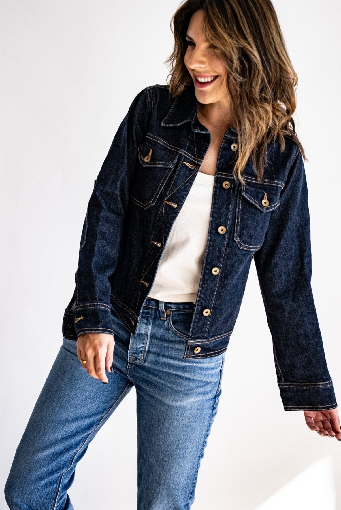 American made dark denim jacket paired with light-wash jeans and a white shirt, styled against a bright white background.
