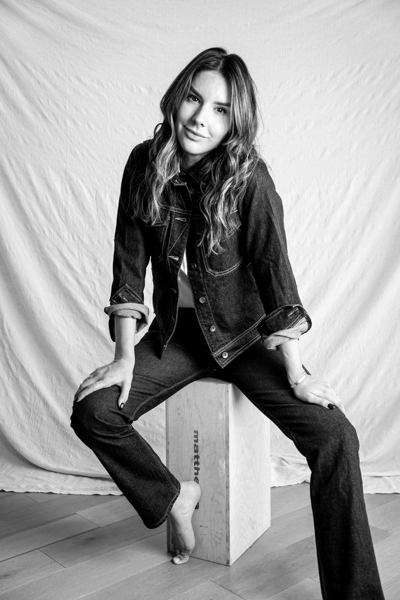 American made denim jacket paired with matching dark jeans, styled in a minimalist black and white portrait.