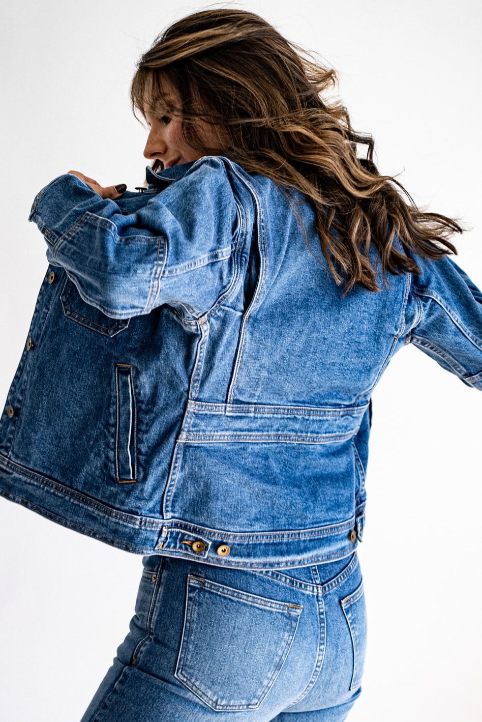 Denim jacket made in USA styled with matching jeans, modeled from a side angle against a white background.