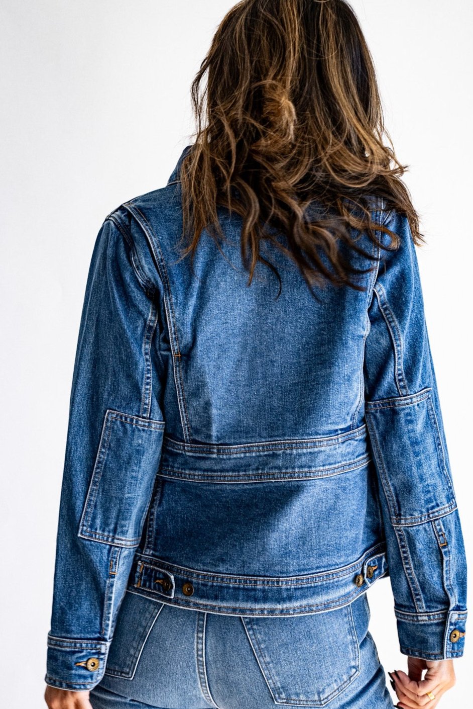 Denim jacket made in USA shown from the back, paired with matching blue jeans against a white background.
