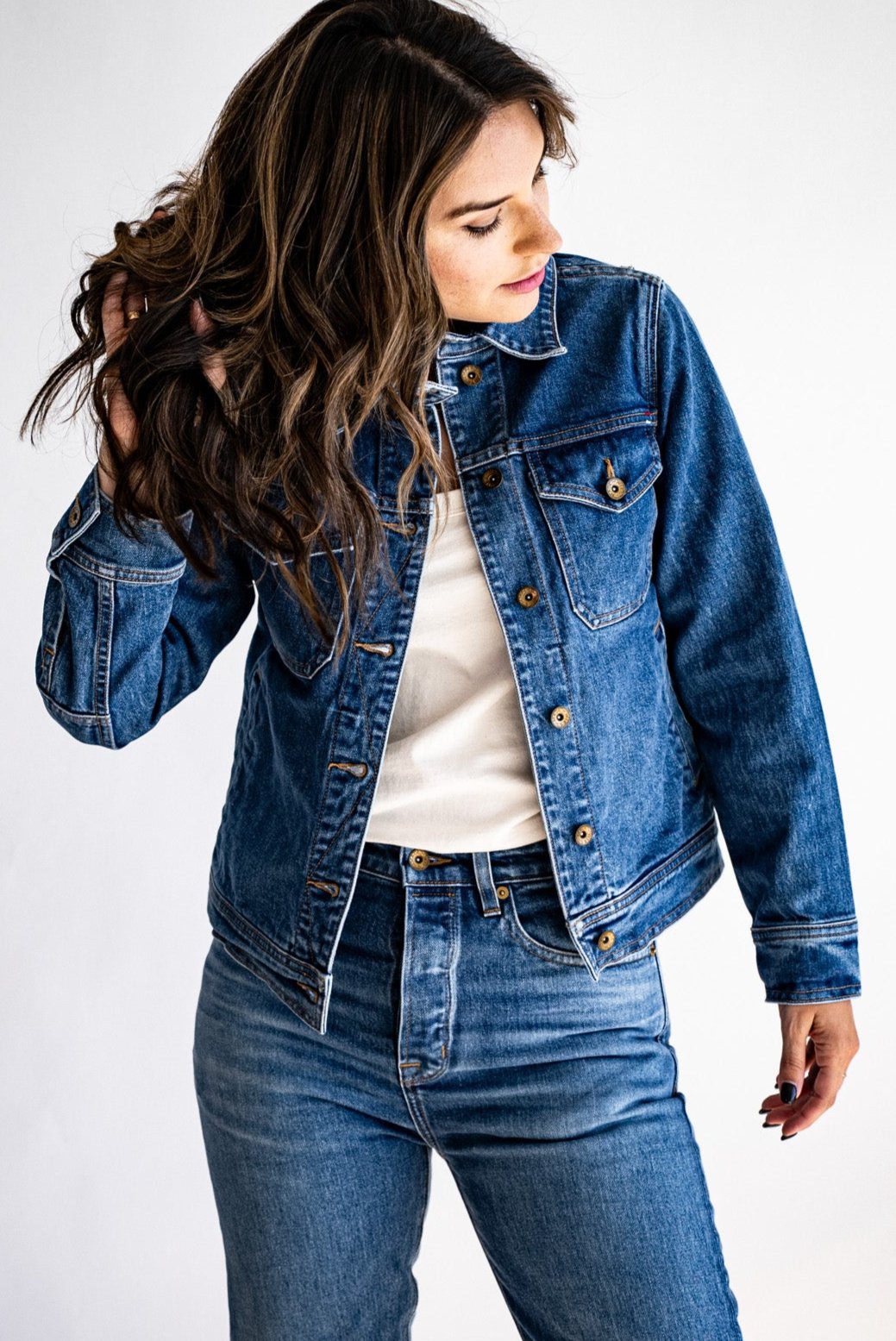 Trucker jacket made in USA paired with high-waisted denim and a white shirt, modeled against a white background.